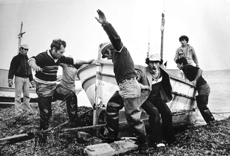 fotografia di Lou Dematteis che raffigura dei pescatori che spingono una barca