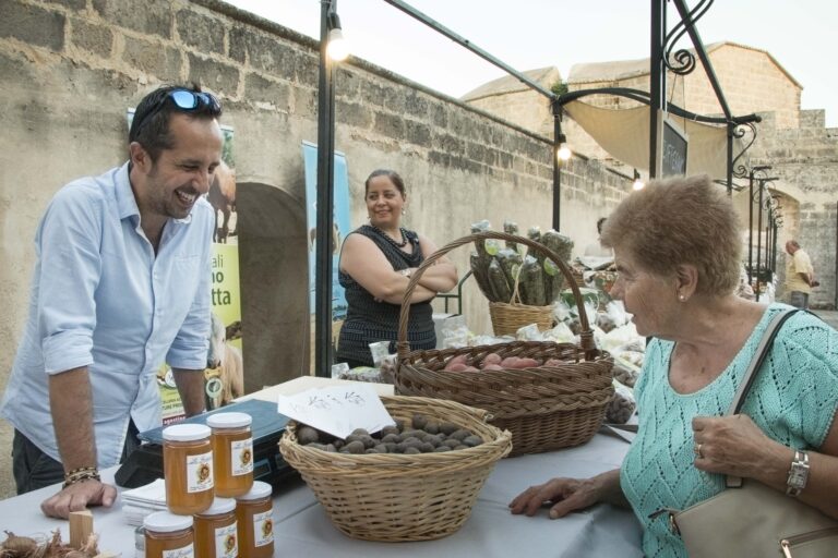 una signora osserva un banchetto di prodotti alimentari all'interno del castello