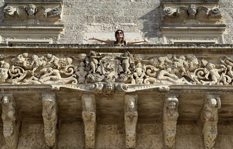 Alessandra De Luca si affaccia sorridente sul balcone della facciata del Castello
