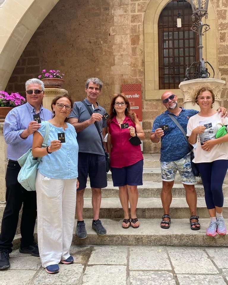 gruppo di visitatori nell'atrio con in mano la chiave del castello