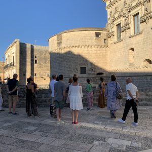 visitatori durante una visita guidata di fronte la facciata del castello